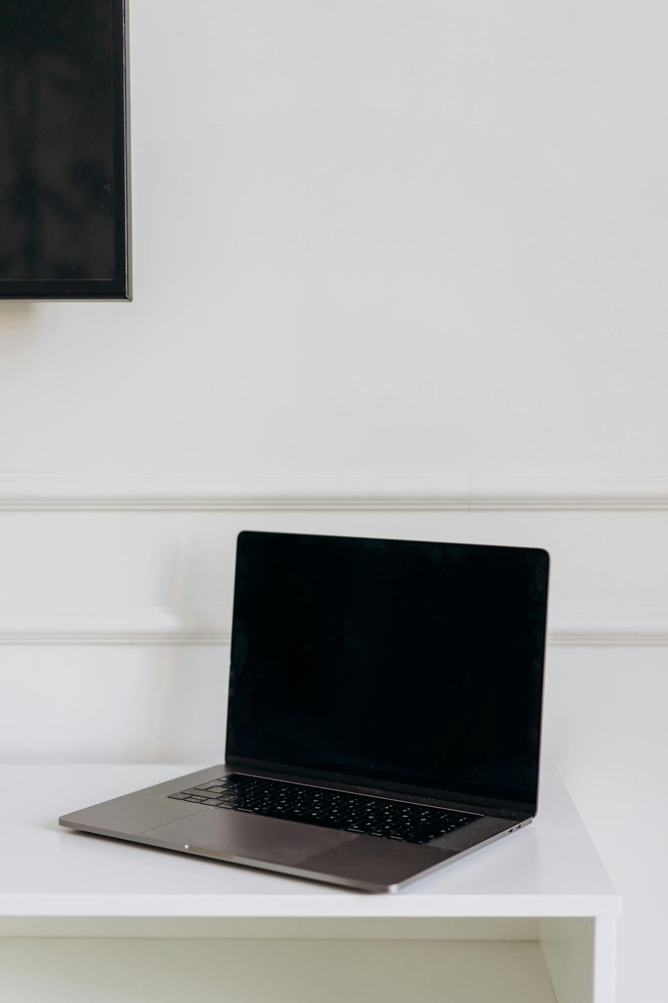 Modern laptop on a clean white table, perfect for tech and workspace themes.